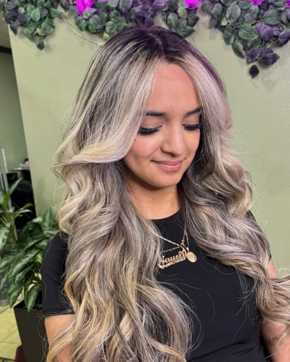 Clienta de D'Vicente Beauty Salon con balayage rubio ceniza y ondas largas